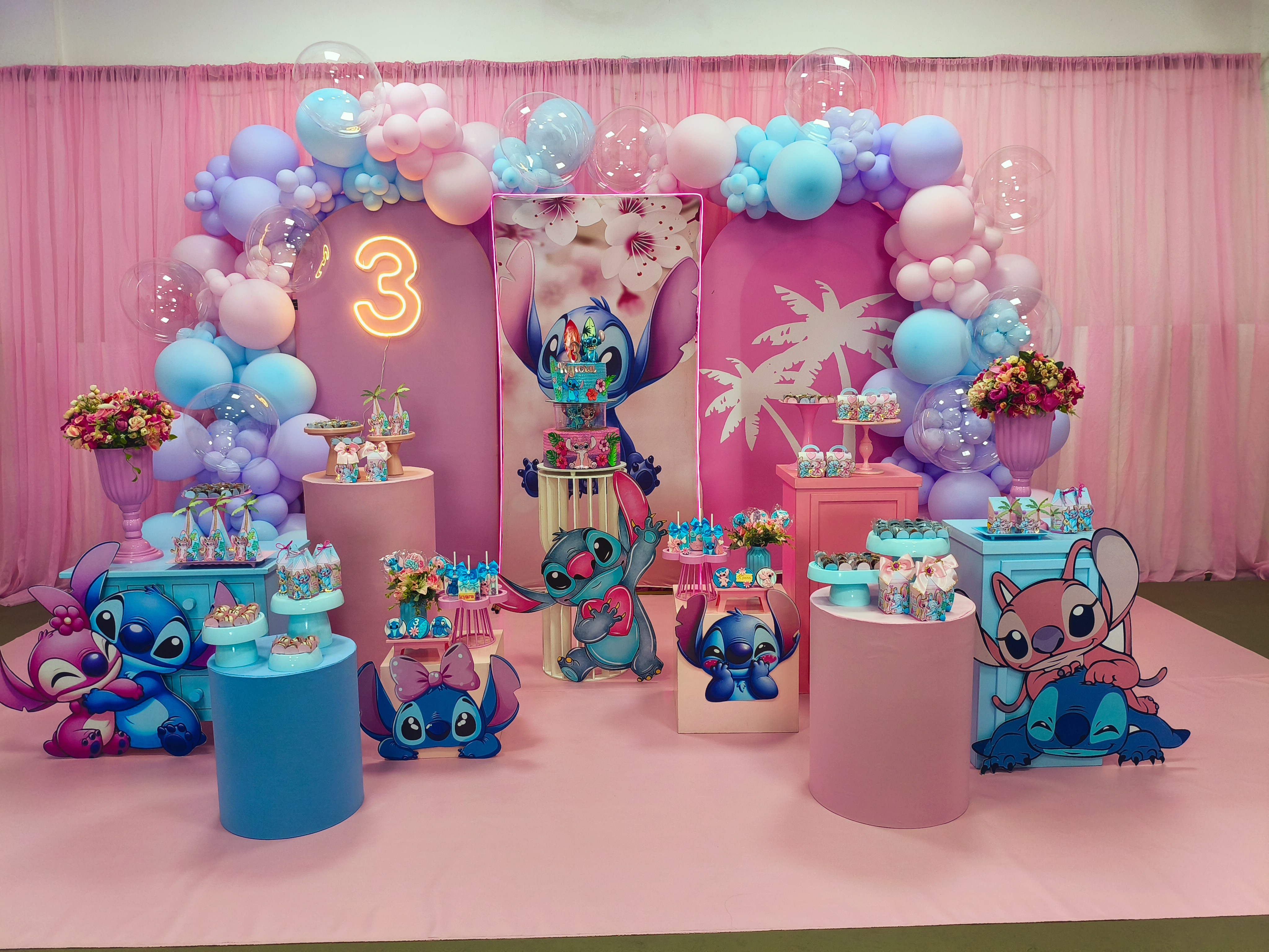 Decoração de aniversário em rosa e azul, com balões, mesas e detalhes temáticos
